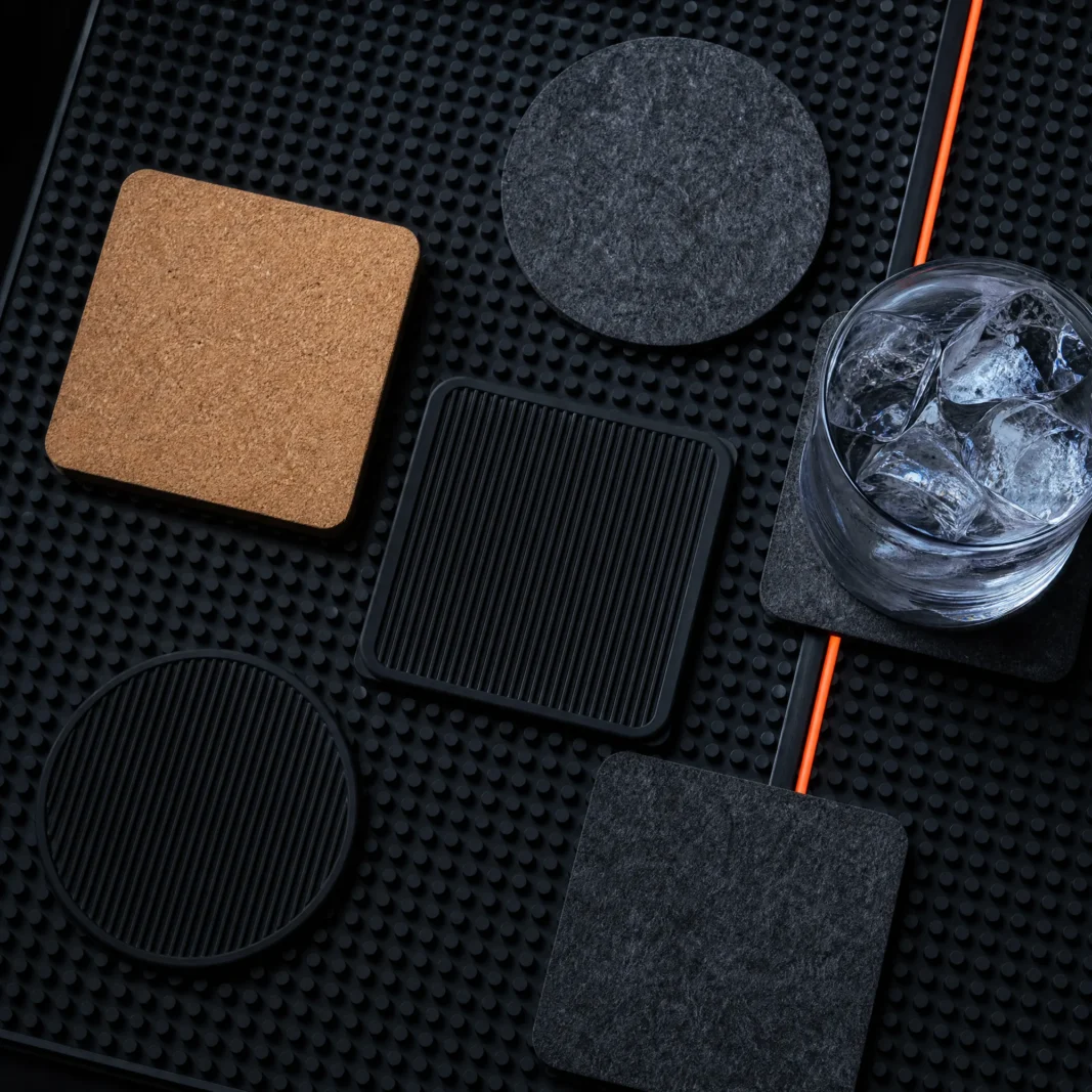 A studded silicone bar mat with cork, felt and silicone coasters