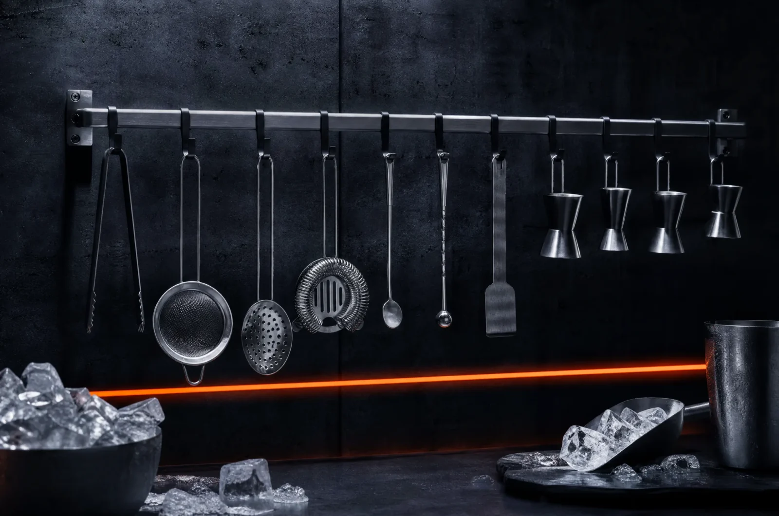 Bar tools hanging from a steel rail against concrete